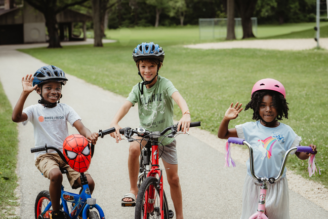 three adorable kids on bikes smiling