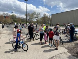 photo of a bunch of people in a parking lot shopping for bikes
