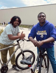 two teen boys smiling with their bikes