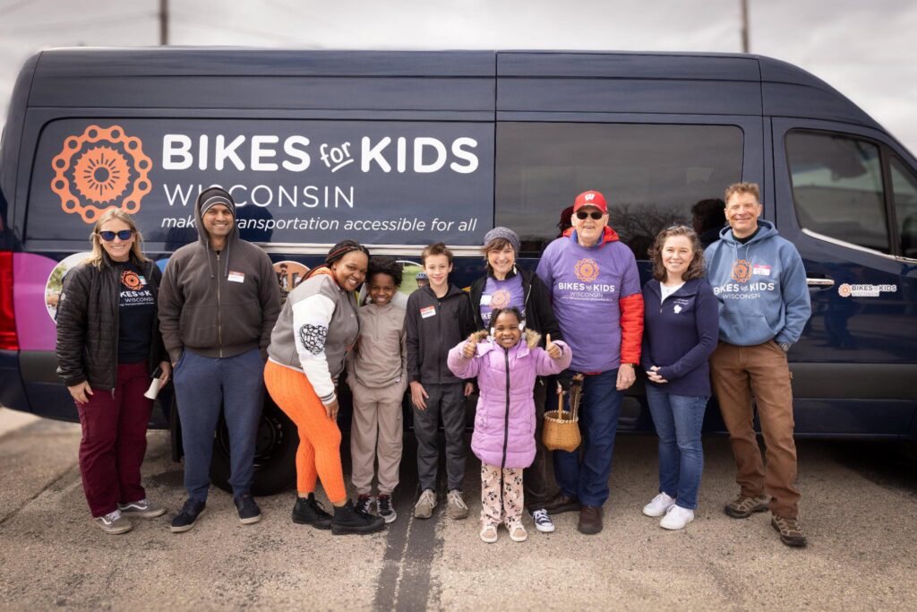 Group of people smiling and standing in front of the bike bus