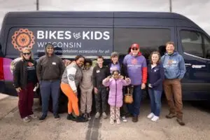 Group of people smiling and standing in front of the bike bus