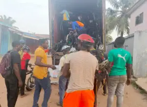 Group of people in Ghana unloading a shipping container of bikes from Madison, WI