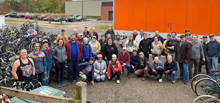 40 volunteers smiling after unloading a semi of bikes