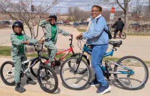 Mom and twin boys on bikes smiling; photo by Kevin Anderson